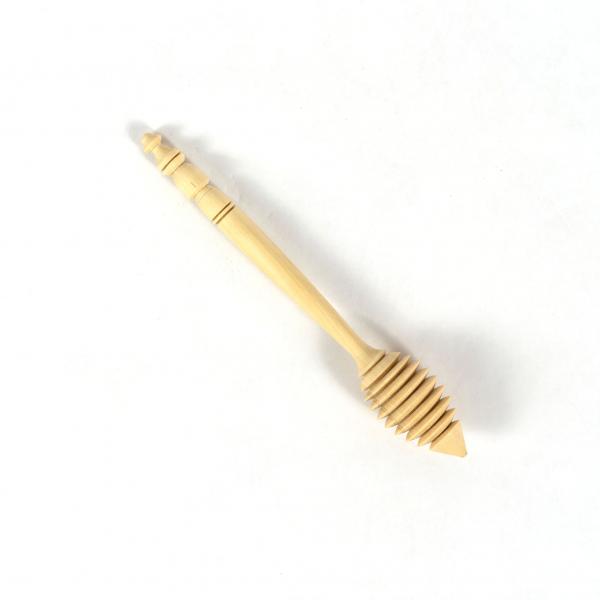 A wood honey dipper hand carved from lemon wood on a white background. 