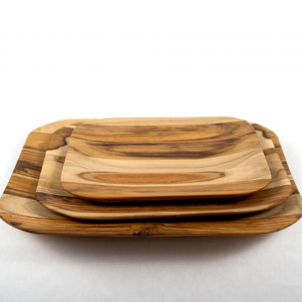 Three sizes of teak wood trays with a graceful curved edge. Stacked on a white background.