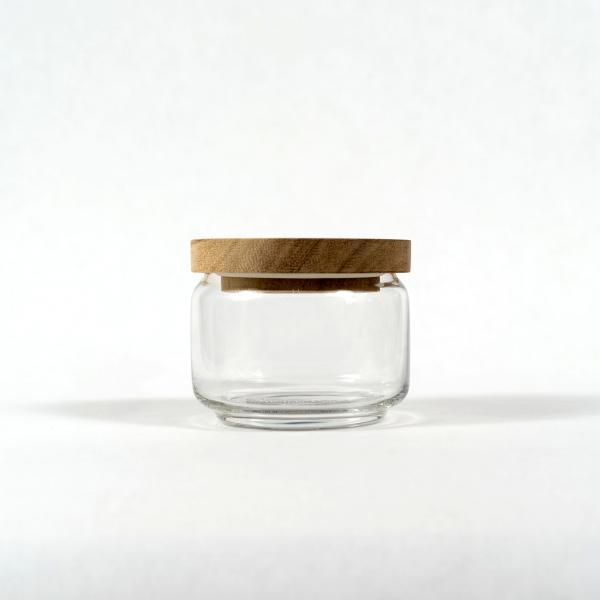 Small size of glass jar with acacia wood lid sitting in front of a white background.