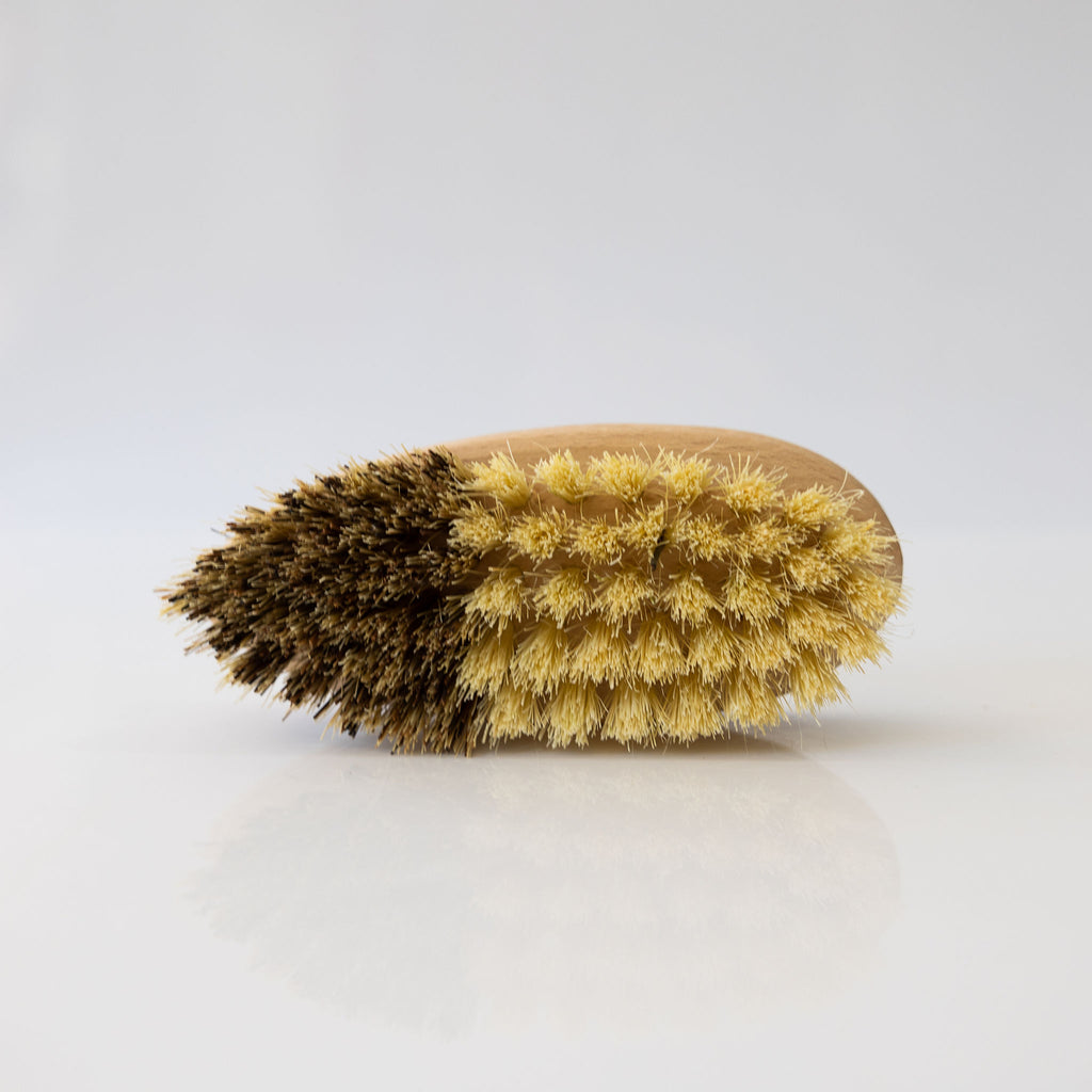 Vegetable brush handmade from plant fibers and beechwood. Photo shows the two tone bristles in golden yellow and dark brown.
