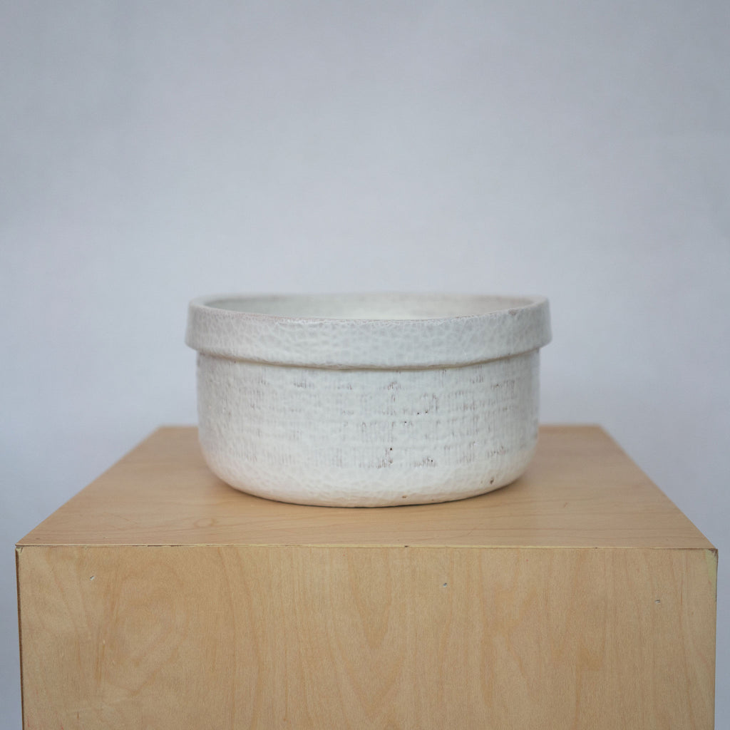 Medium white ceramic bowls on a wood platform in front of a white background.