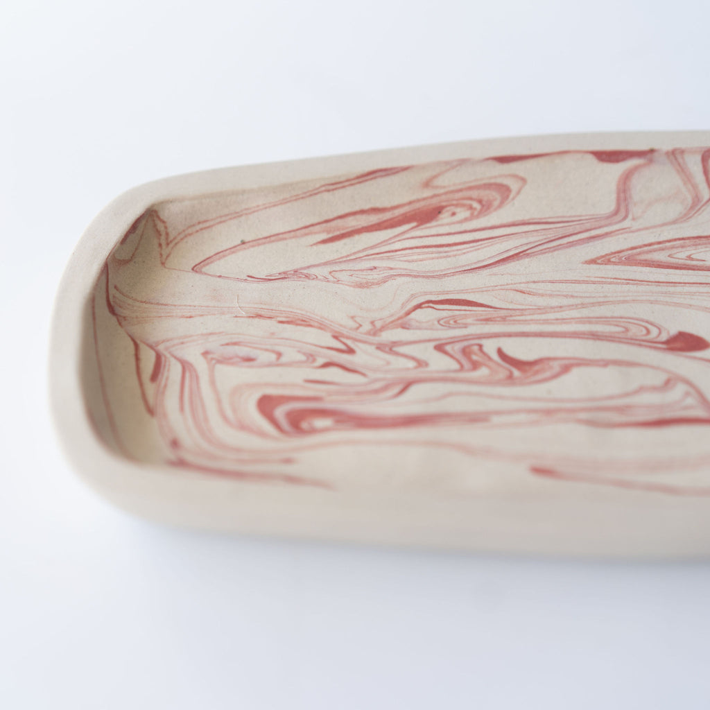 Close up of pink marbled rectangular plate with a slightly raised edge.