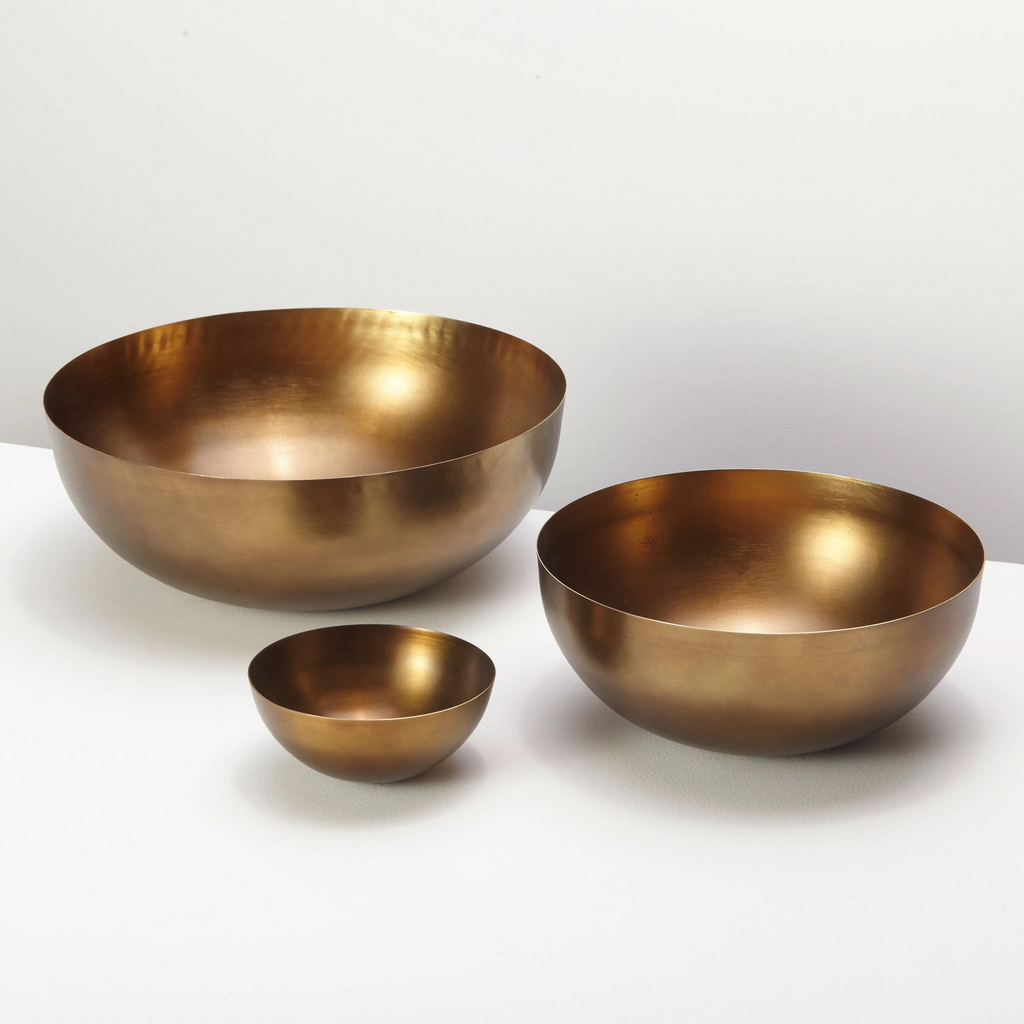 Group of three cobbled antiqued bronze bowls sit together on white background.