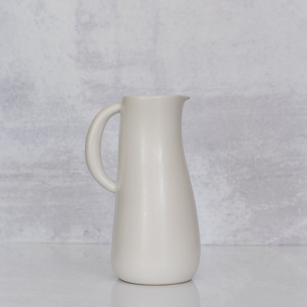 Curvy matte white handled stoneware jug from Tunisia.