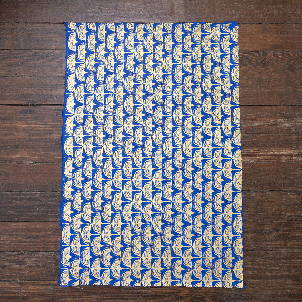 Handmade and printed paper gift wrap. Pattern is repeat Gold cranes on bright blue background.