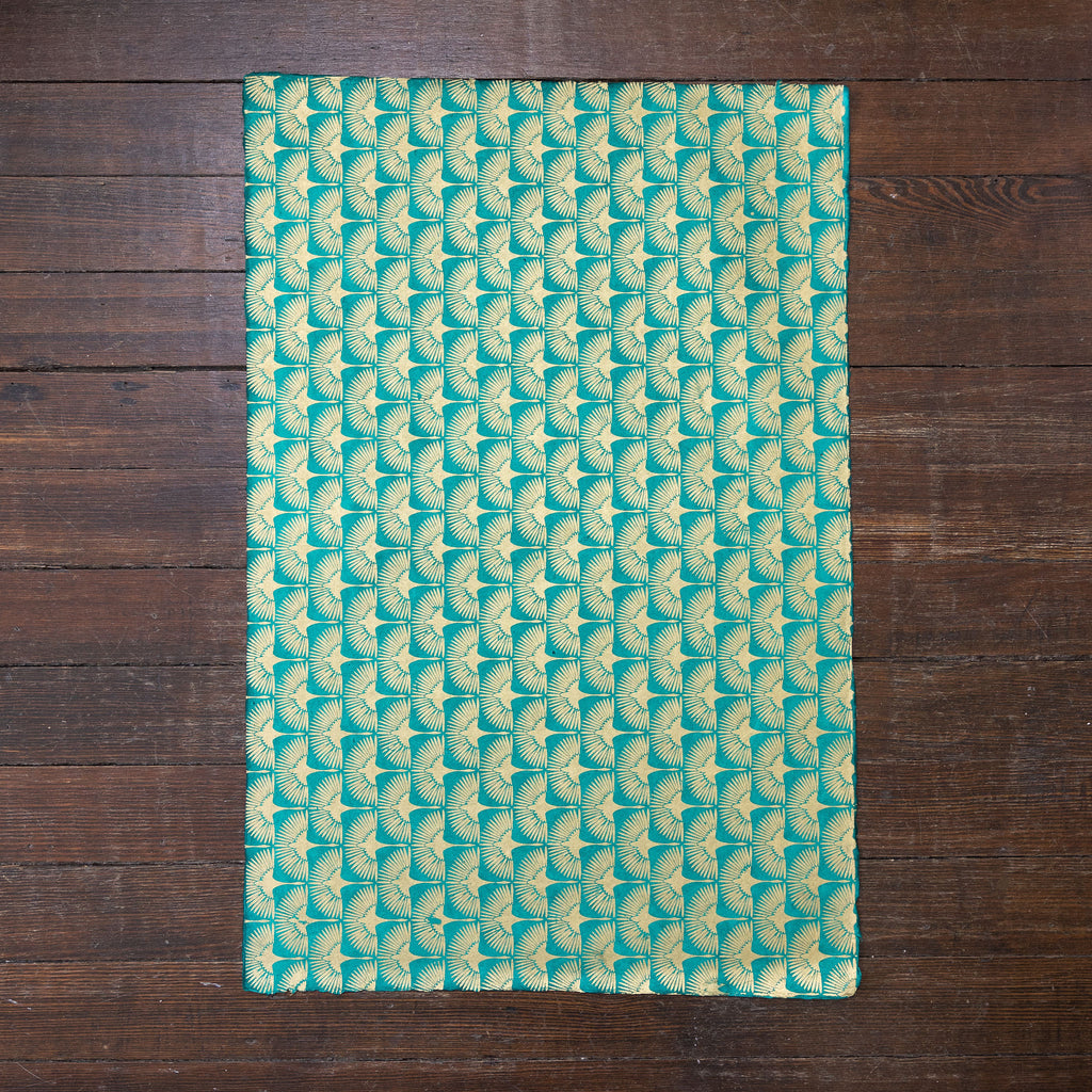 Handmade and printed paper gift wrap. Pattern is repeat Gold cranes on teal background.