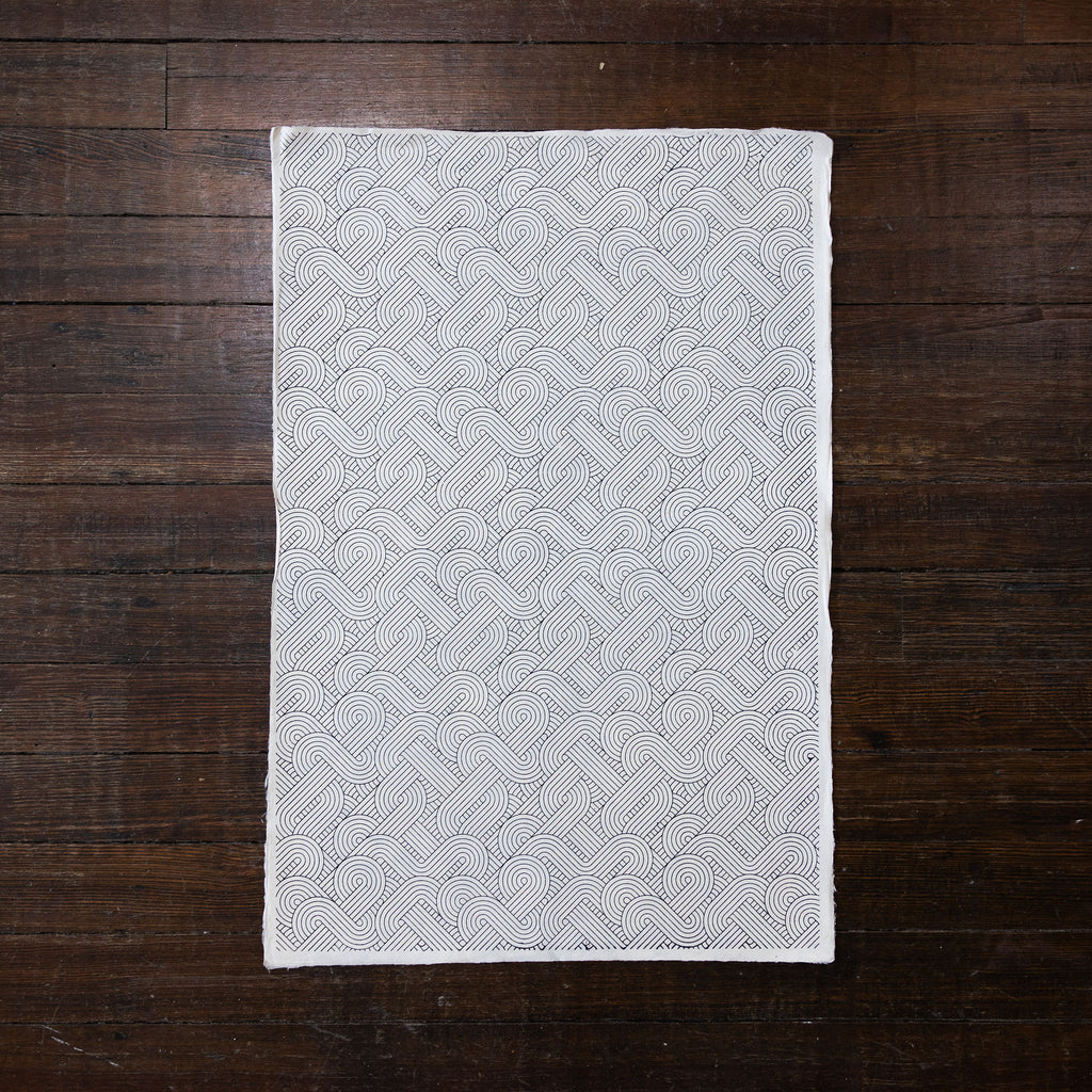 Handmade and printed paper gift wrap. Pattern is repeat art deco gray geometric pattern on white background.