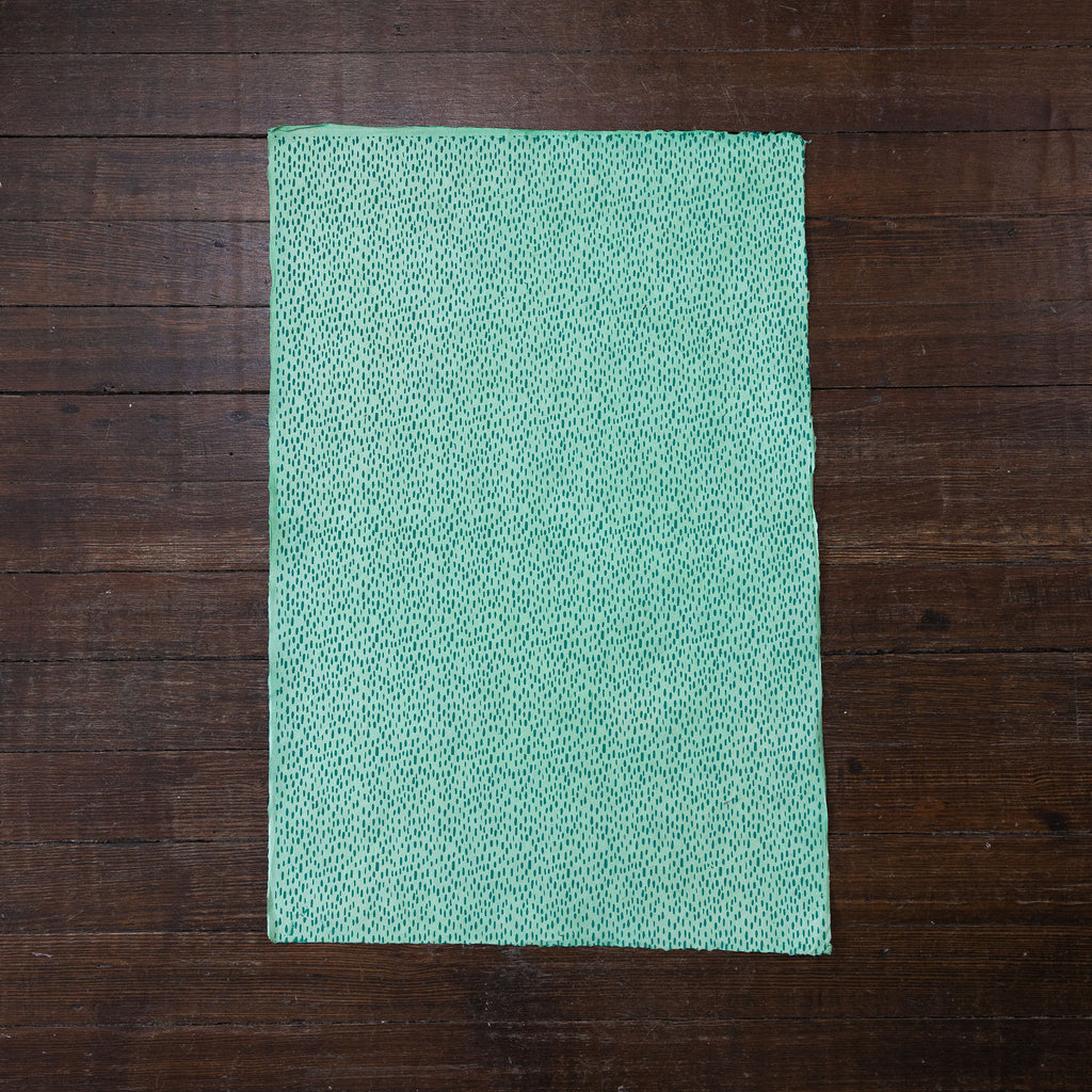 Handmade and printed paper gift wrap. Pattern is repeat teal raindrops on mint background.