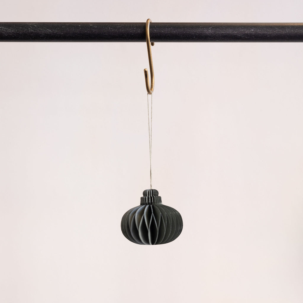 Recycled paper accordion tree ornament in Antique Teal hanging from a brass hook on a black bar in front of a white background.