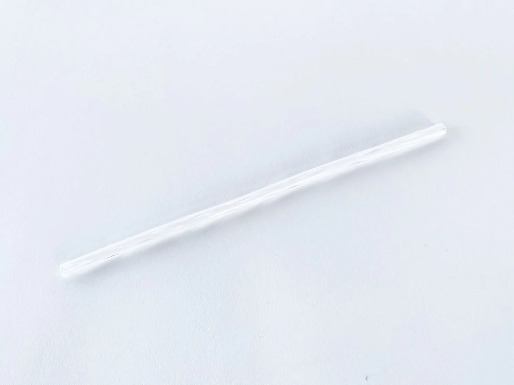 Glass straw twisted with clear and white colors on a white background.