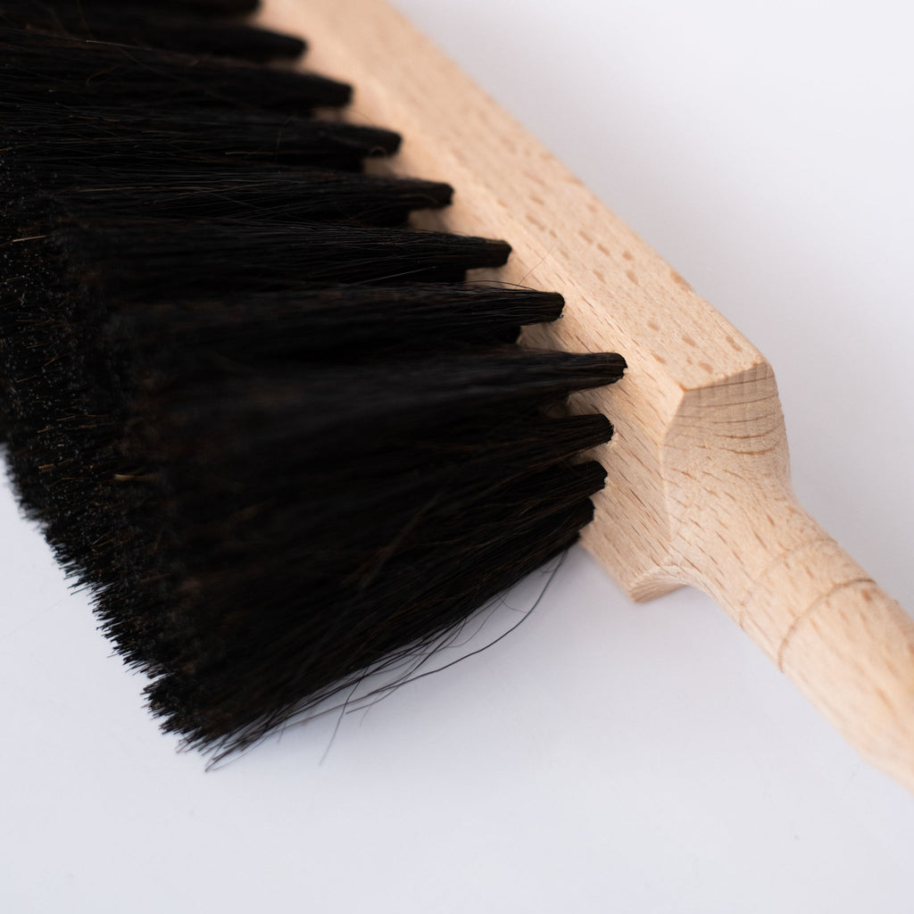 Beechwood handle and black horsehair brush on white background. Close up angle of bristles.