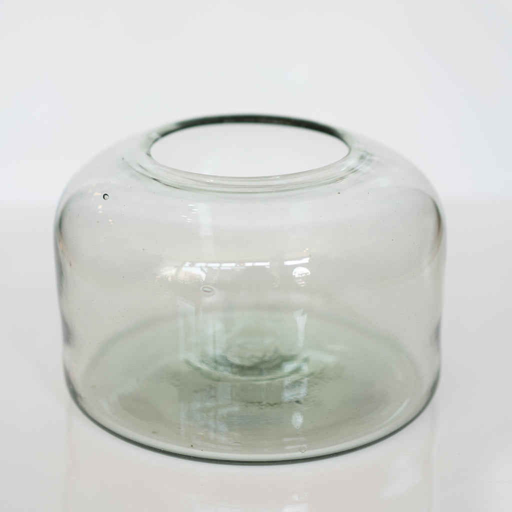 Organically shaped round flat-bottomed large handblown glass vase on white background.