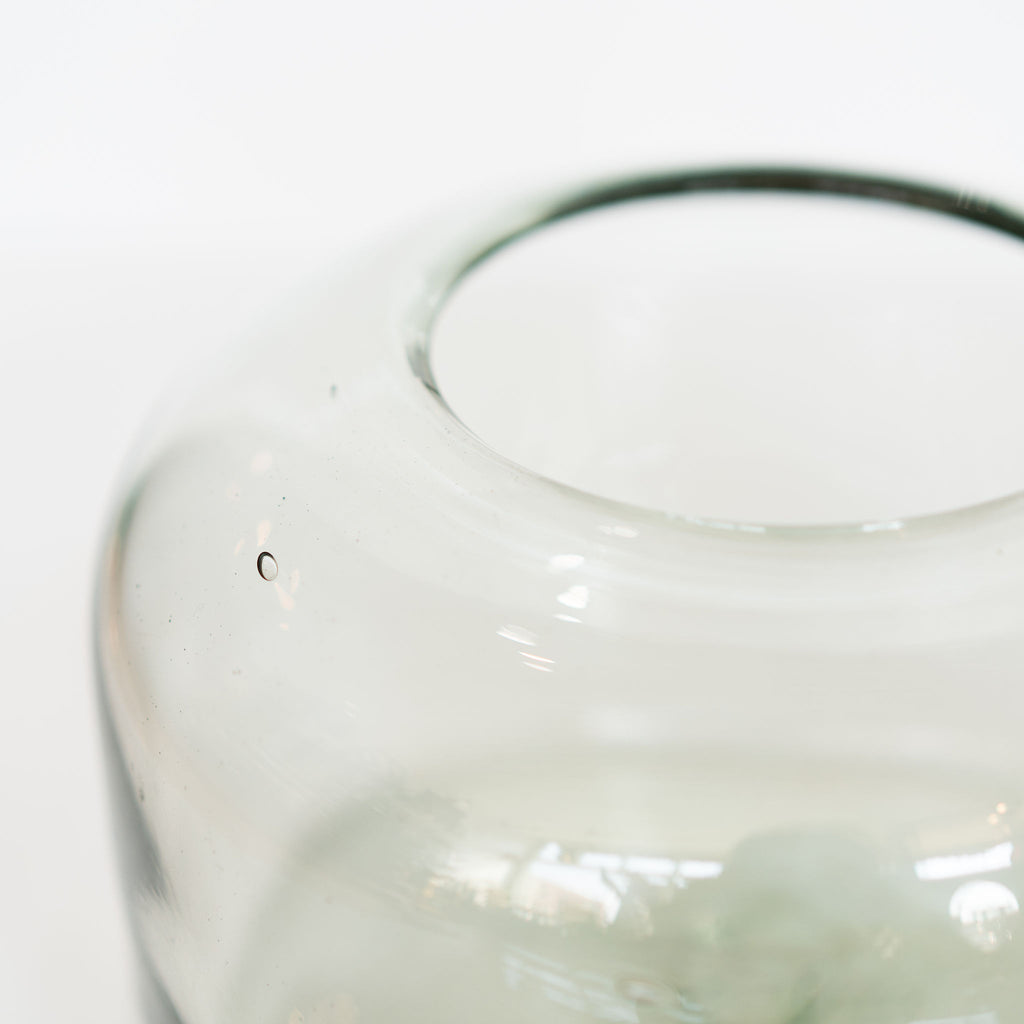 Organically shaped round flat-bottomed large handblown glass vase on white background.