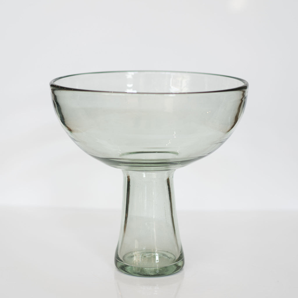 A large bouquet shaped handblown glass vase with skinny bottom and large bowl on top. White background.