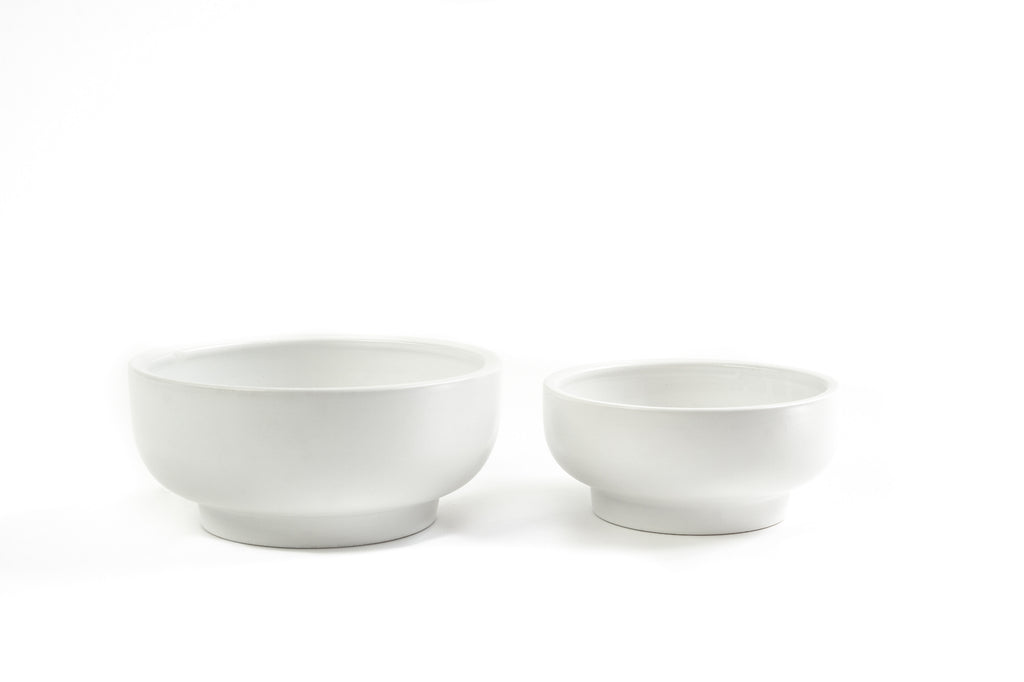 Pair of white porcelain bowls with slightly exaggerated pedestal on bottoms.