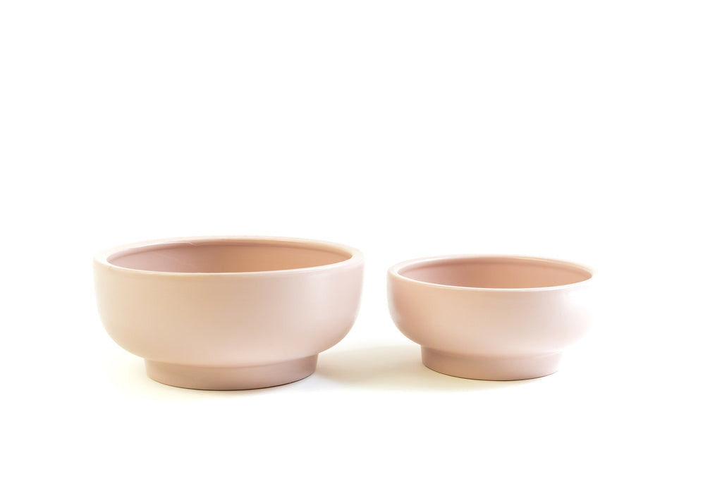 Pair of blush pink porcelain bowls with slightly exaggerated pedestal on bottoms.