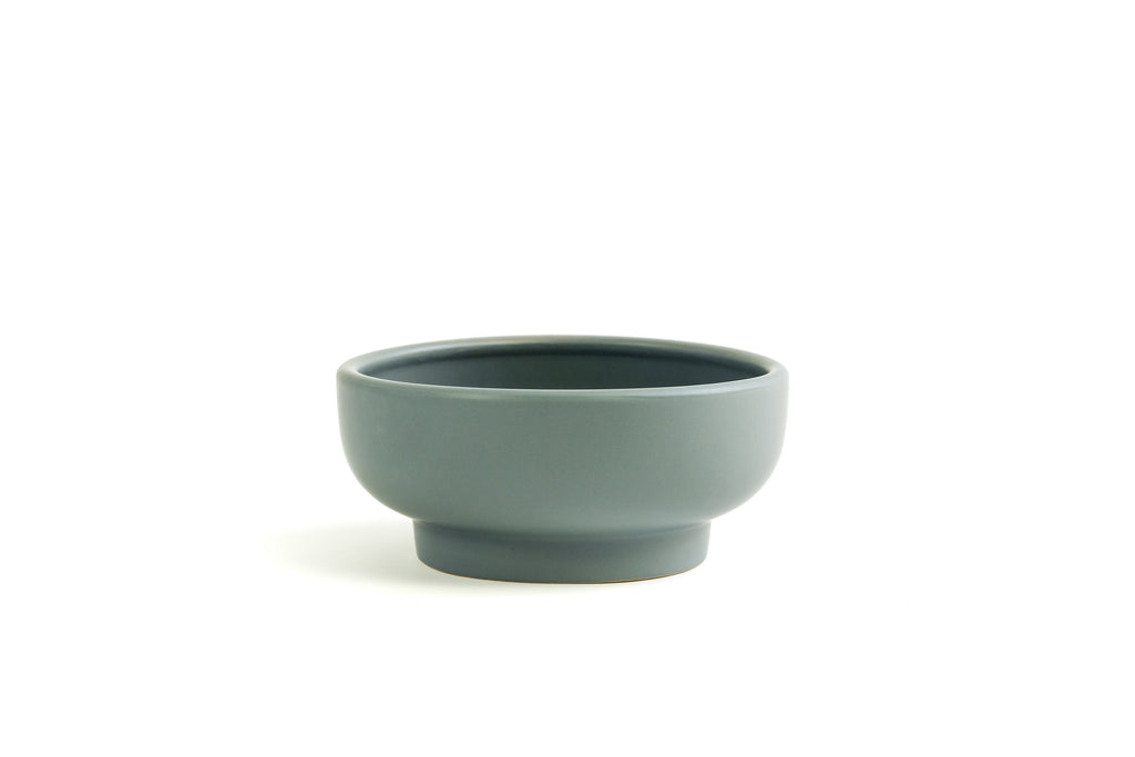 Gray porcelain bowl with slightly exaggerated pedestal on bottom.