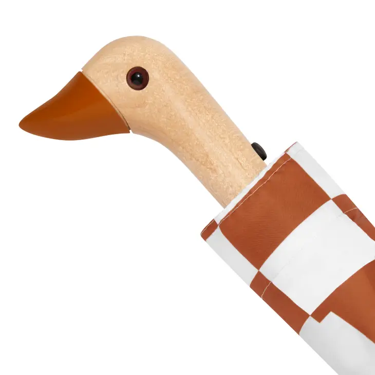 Close up of duck head handle on a clay and cream checkered duckhead compact umbrella on a white background.