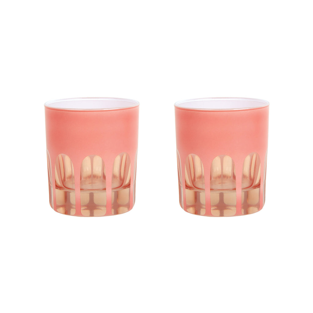 Pair of coral toned handblown glasses with a mix of opaque and transparent arches along the bottom. White background.