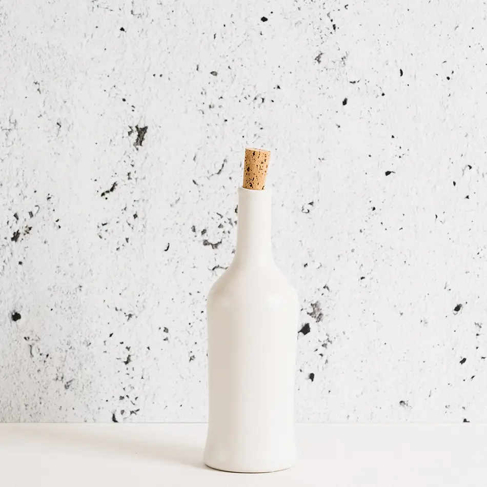 Matte White Stoneware Olive Oil Bottle with cork against a marbled background.