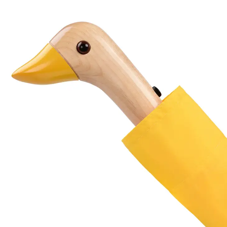 Close up of duck head handle on a yellow duckhead compact umbrella on a white background.