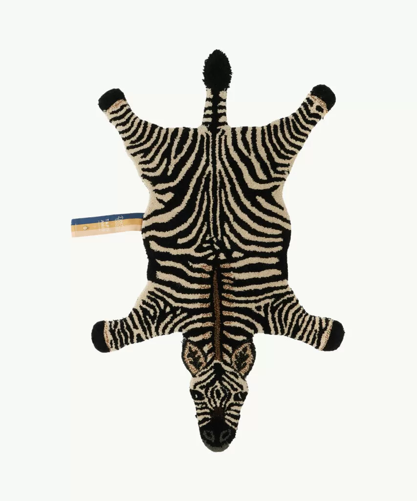 Hand-tufted wool rug shaped like a zebra laying flat on a white background.